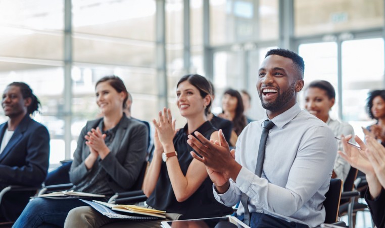 Group of colleagues clapping at a meeting